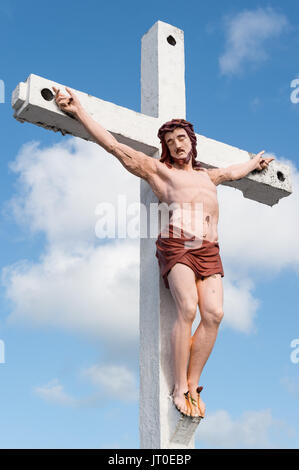 Jesus Christ on the cross over blue sky with clouds Stock Photo
