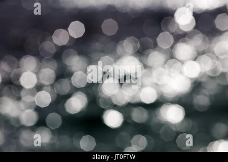 Abstract creative background of aperture sun stars reflecting off of a shimmering sea surface in bright summer light. Stock Photo