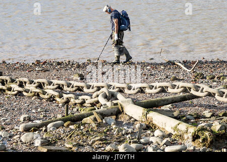 London, UK. 7th August, 2017. An afternoon mudlarker scans the River Thames foreshore near Greenwich with a metal detector searching for remnants of the past. © Guy Corbishley/Alamy Live News Stock Photo