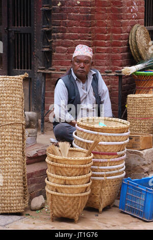 Nepalese man selling braided wicker baskets on a street of  Bhaktapur Stock Photo