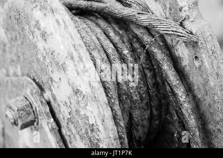 Closeup image of an old, rusted winch from a boat trailer, showing the frayed steel cable. Stock Photo