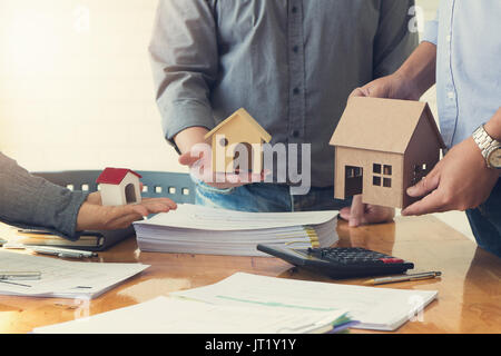 Engineer and Architect concept, Engineer Architects office team working and discussing house plan with blueprints and house model, Vintage Effect Stock Photo