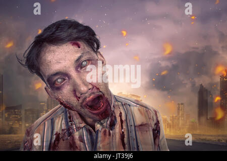 Close up of spooky asian zombie man in the burning city Stock Photo