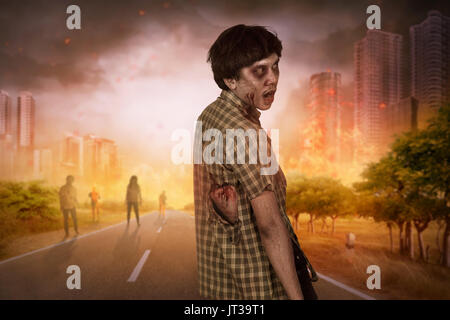 Aggressive asian zombies with blood walking around on the burning city Stock Photo