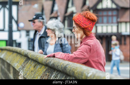 People standing on a bridge looking over at the river below, in Arundel, West Sussex, England, UK. Stock Photo