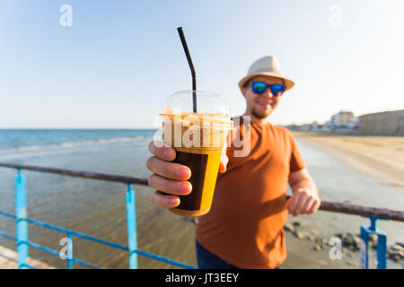 Young handsome man holding cup of take-out coffee Stock Photo