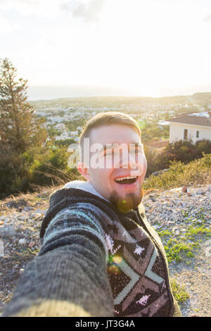 Handsome bearded man taking selfie. Happy student makes funny picture for his blog. Stock Photo
