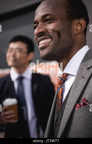 young smiling multiethnic businessmen meeting at coffee break outdoors, business team meeting Stock Photo