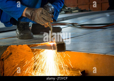 Man cutting metal with fire from a welding cutting torch Stock Photo