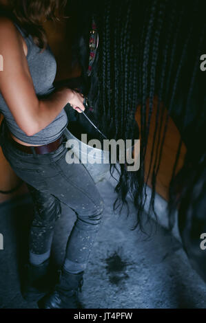 female horseman holding a bucket of water quenching thirst  Friesian horse, in a stable on a farm, caring for thoroughbred pets Stock Photo