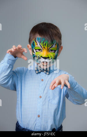 lovely adorable kid with paintings on his face as a tiger or lion Stock Photo