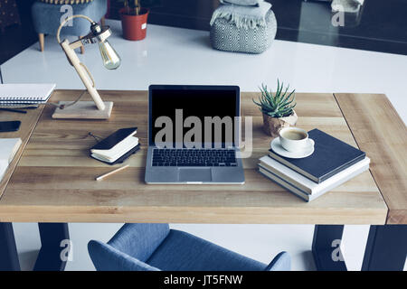 An open laptop computer with blank screen, coffee cup and notebook on ...