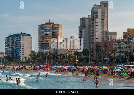 Hundreds of bathers enjoy summer in crowded El Campello beach, Alicante, Spain Stock Photo