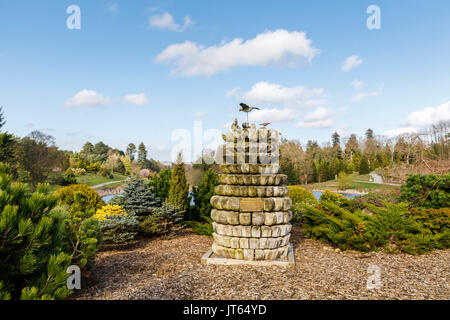 Wooden sculpture commemorating the opening of Bedgebury National Pinetum in 2000, Bedgebury, Kent south-east England on a sunny spring day, blue sky Stock Photo