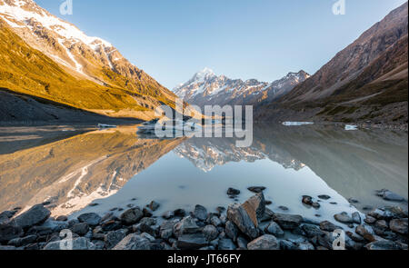 Sunrise, reflection in Hooker Lake, Mount Cook illuminated by morning sun, Mount Cook National Park, Southern Alps Stock Photo
