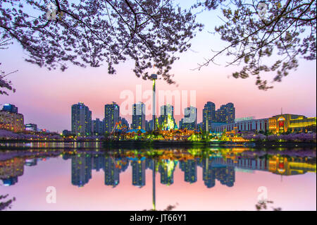 SEOUL, KOREA - APRIL 9, 2015: Lotte World amusement park at night and cherry blossom of Spring, a major tourist attraction in Seoul, South Korea on Ap Stock Photo