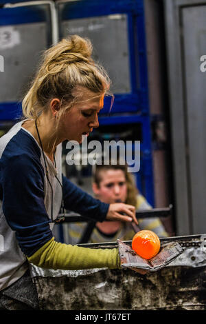 Glass Blowing Workshop - Two Women Shaping glass on the Blowpipe Stock Photo