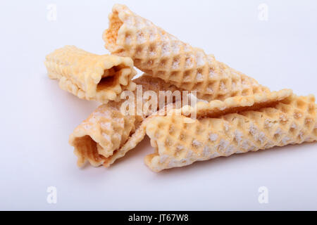 Homemade wafer rolls with powdered sugar isolated on white background Stock Photo
