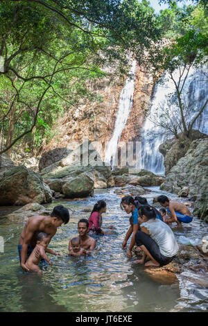 Families with kids make refreshing bath in natural pool at Na Muang or Namuang Waterfall Park, Koh Samui island, Thailand Stock Photo
