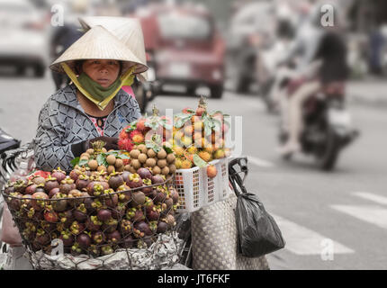 Woman selling fruits and vegetables on street in Saigon Vietnam. Stock Photo