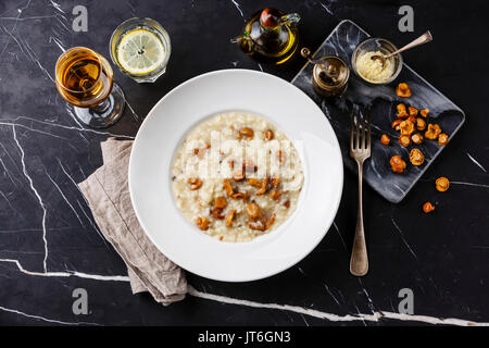 Risotto with chanterelle mushroom on plate on dark marble table background Stock Photo