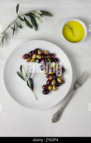 Black and green olives in the dish over the table Stock Photo
