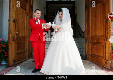 Gorgeous wedding couple releasing wedding white doves into the air. Stock Photo