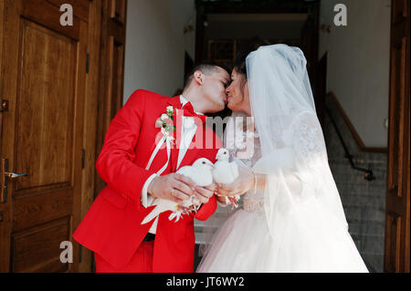 Gorgeous wedding couple releasing wedding white doves into the air. Stock Photo