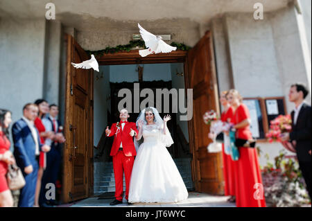 Gorgeous wedding couple releasing wedding white doves into the air. Stock Photo