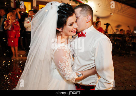 Fantastic wedding couple dancing their first dance in the restaurant with confetti. Stock Photo