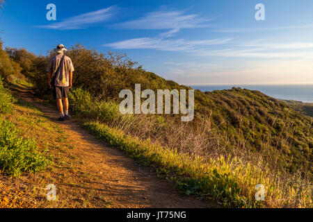 Hiker sees ocean beyond Zuma Canyon along the Canyon View Trail at Zuma Canyon in Malibu, California Stock Photo