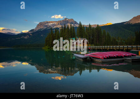Canoes on beautiful Emerald Lake with lake lodge and restaurant in the background at sunset, Yoho National Park, Canada. Stock Photo