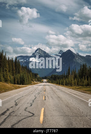 Scenic view of the road and canadian rockies on Icefields Parkway. It travels through Banff and Jasper National Parks and offers spectacular views of  Stock Photo