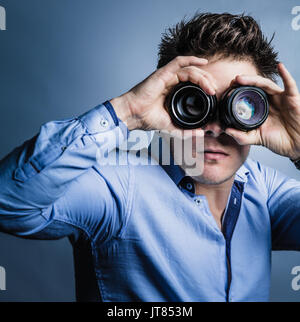 Photographer's Vision Concept. Man Looking Through Lenses in Studio Stock Photo