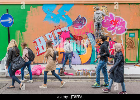 London, UK. 8th Aug, 2017. Their work Apollo takes shape in Berwick Street. PichiAvo: In Gods We Trust – a new commission and exhibition at Unit London, Wardour Street, by Spanish artists PichiAvo. Both the exterior facade and interior walls of Unit London's downstairs gallery are colour covered from head-to-foot by PichiAvo's unique blend of graffiti and fine art styles. Credit: Guy Bell/Alamy Live News Stock Photo