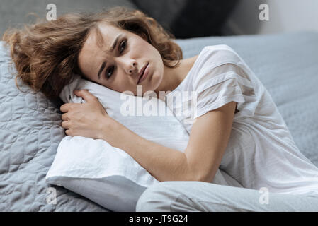 Depressed tired woman lying on the pillow Stock Photo