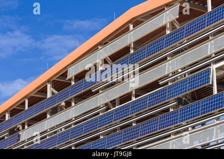 Solar panel designed to absorb the sun's rays as a source of energy for generating electricity or heating hanging from the side of a parking lot. Stock Photo