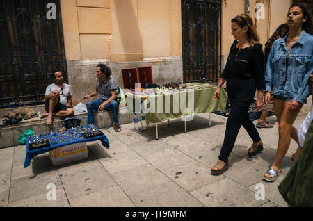 Valencia, Spain - June 3, 2017: Tourists and sellers of flea market close to Cathedral having a lot of vintage ornaments, bracelets, earrings, handmad Stock Photo