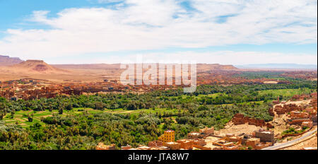 Panorama of the Tinghir oasis on the Todgha River in Morocco, Africa, with lush green palm trees and the Atlas mountains in the background. Stock Photo