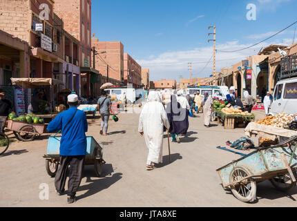 Rissani, Morocco -  May 09, 2017: Moroccan vendors deliver fresh fruits and vegetables in their push carts to the food stalls while the locals are sho Stock Photo