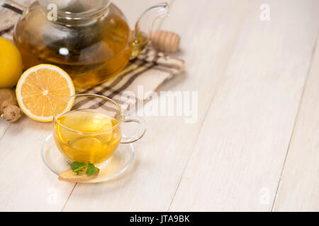 Cup of ginger tea with lemon and honey on white wooden background. Stock Photo