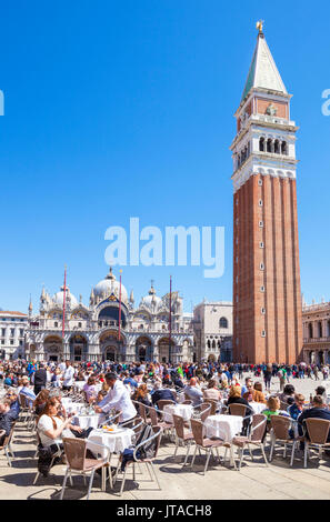 Campanile, Basilica di San Marco, Piazza San Marco, tourists and the cafes of St. Marks Square, Venice, UNESCO, Veneto, Italy Stock Photo