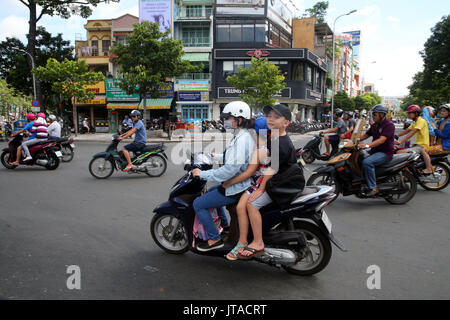 Mother and children on motor scooter on Saigon Street, Ho Chi Minh City, Vietnam, Indochina, Southeast Asia, Asia Stock Photo