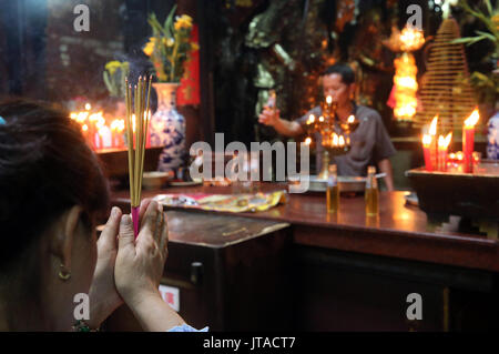 Buddhist worshipper burning incense sticks, Taoist temple, Jade Emperor pagoda (Chua Phuoc Hai), Ho Chi Minh City, Vietnam Stock Photo