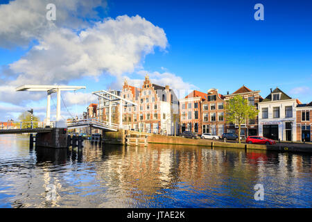 Blue sky and clouds on typical houses reflected in the canal of the River Spaarne, Haarlem, North Holland, The Netherlands Stock Photo