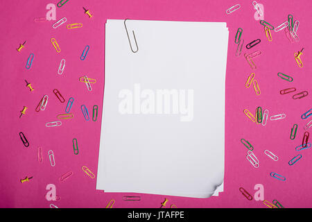 Top view of blank white papers and colorful paper clips isolated on pink Stock Photo