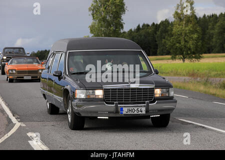 SOMERO, FINLAND - AUGUST 5, 2017: Tuned Cadillac Fleetwood funeral car with led lights and skull detail moves along scenic highway on Maisemaruise 201 Stock Photo