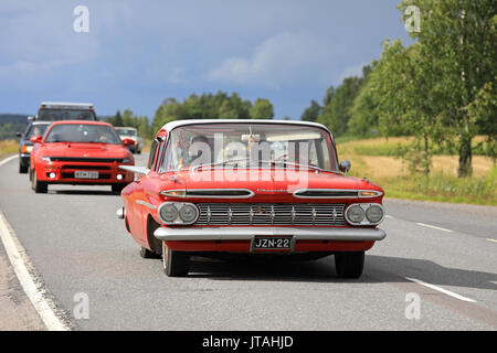 SOMERO, FINLAND - AUGUST 5, 2017: Second generation Red Chevrolet Impala Sedan, probably 1959, moves along highway on Maisemaruise 2017 car cruise lat Stock Photo