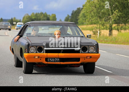 SOMERO, FINLAND - AUGUST 5, 2017: Tuned Chevrolet with funny detail of plastic head of the Ex through the hood moves along highway on Maisemaruise 201 Stock Photo