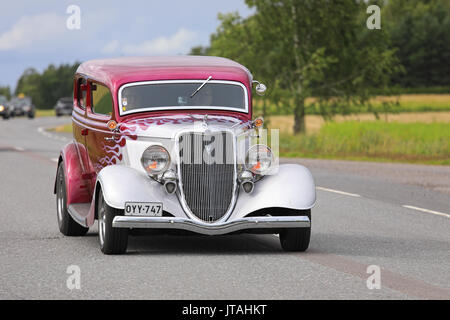 SOMERO, FINLAND - AUGUST 5, 2017: Classic Hot Rod Ford car with magenta flame pattern moves along rural highway on Maisemaruise 2017 car cruise in Taw